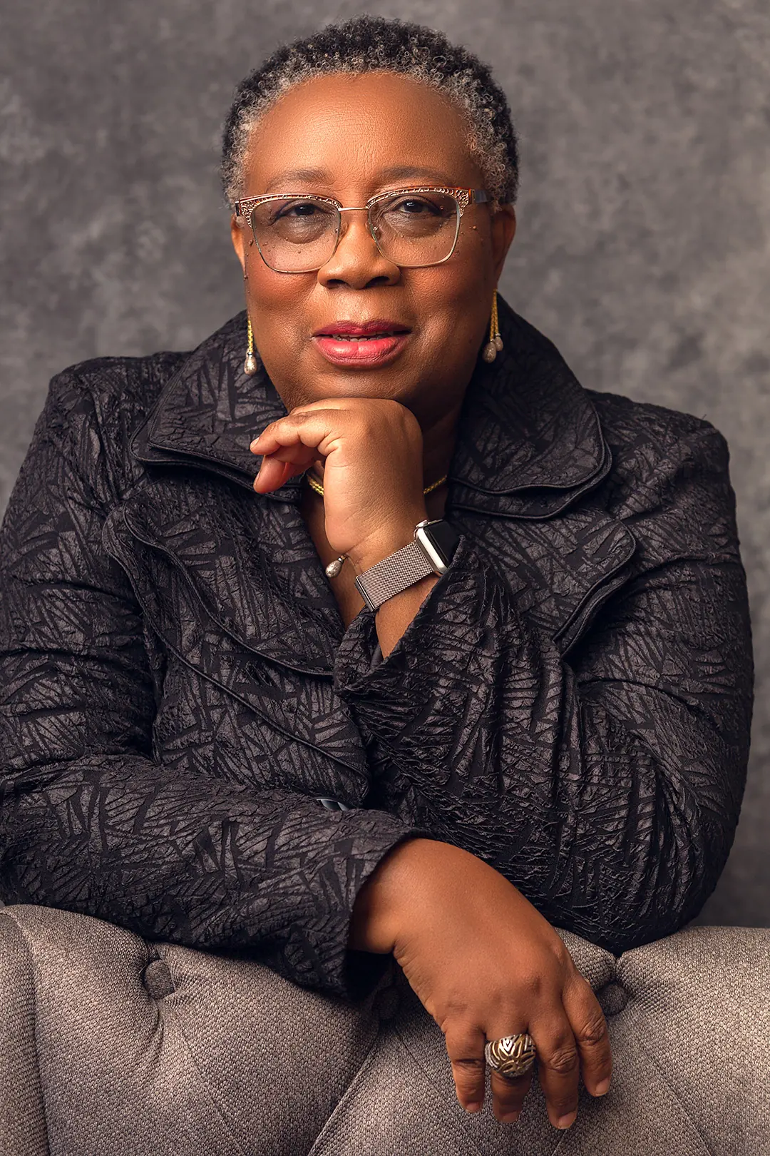 A close portrait of Folasade Adefisayo with her hand at her chin, looking to camera.