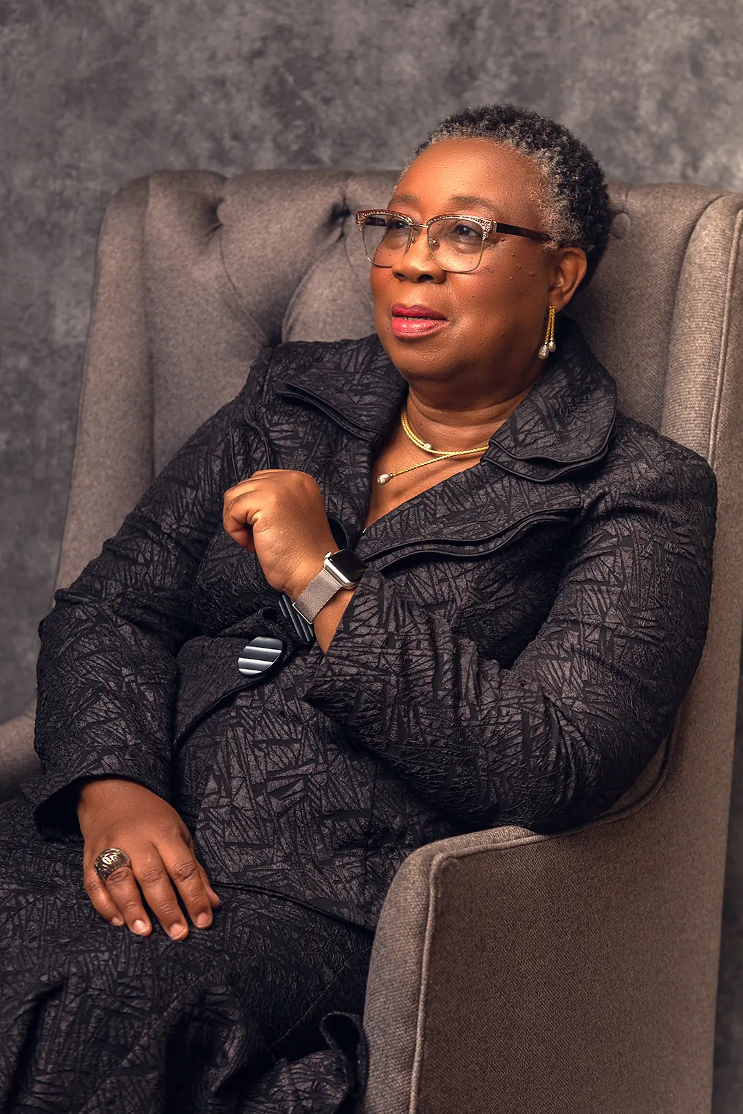 Folasade Adefisayo seated in a wing chair, turned slightly from the camera.