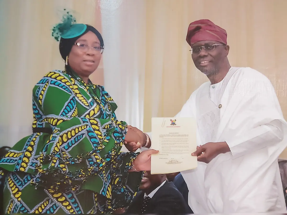 Folasade Adefisayo receiving a document from Governor Babajide Olusola Sanwo-Olu.